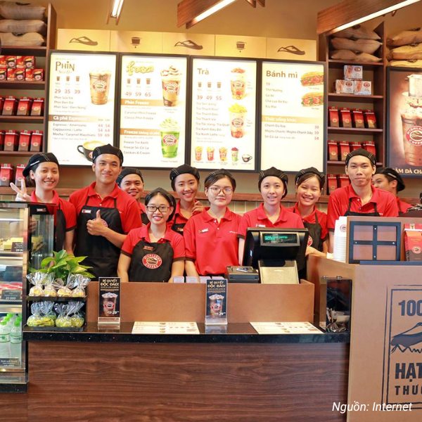 Nhân viên Highlands Coffee trong đồng phục polo đỏ – đen đặc trưng.