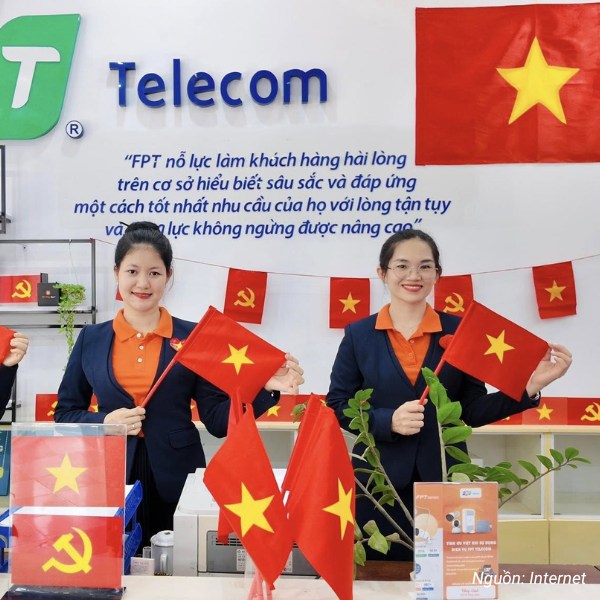 Đồng phục nhân viên FPT Telecom với áo polo cam và áo vest xanh than